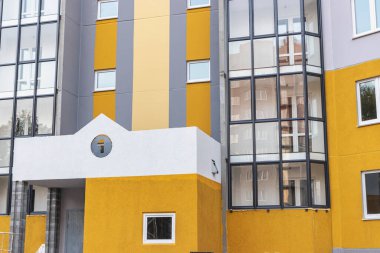 Çok katlı yeni bir binanın ön cephesinde son inşaat çalışması. İnşaat alanının görevlendirilmesi