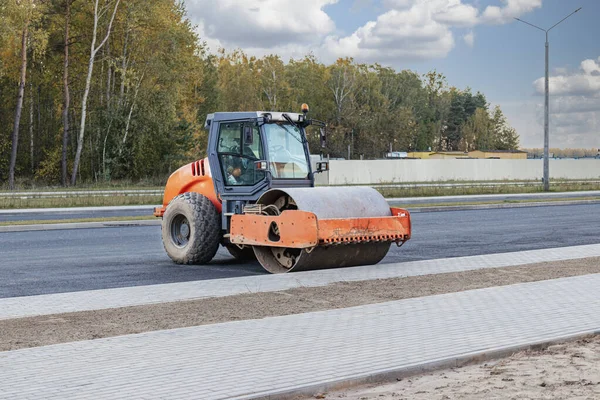 Asfalt kaldırım için ağır titreşimli silindir. Yol yapımı. Yol yapımı ve şehir ulaşımı iletişimi. Ağır makineler