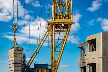 Kule vinci bulutlu gökyüzünün arka planına yakın çekim yapıyor. Modern konut inşaatı. Endüstri mühendisliği. Konut kredisi inşaatı