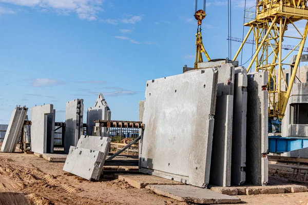 Depoda inşaatı bekleyen beton paneller var.
