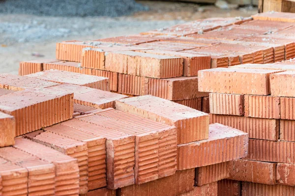 Bir inşaat sahasına istiflenmiş kırmızı seramik tuğlalar. İnşaat malzemeleri. Ev yapmak için kırmızı tuğla