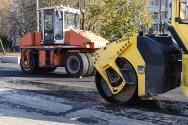 Asfalt beton işçiliği ve yol onarımı için iki ağır titreşim yol silindiri. Asfalt kaldırımı onarılırken ağır makineler