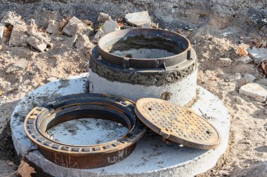 Bir yolu tamir ederken dökme demir kapaklı kanalizasyon halkası kurulur. Yuvarlak metal kapakla iyice boşalt.
