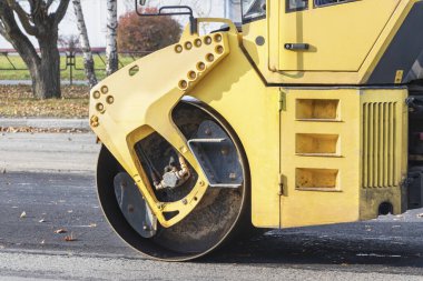 Asfalt beton işleri ve yol onarımı için ağır titreşimli yol silindiri. Yakın plan. Asfalt kaldırımı onarılırken ağır makineler