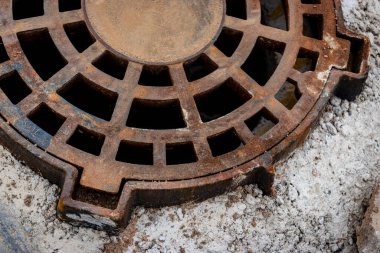 Asfalt kaldırımından önce yoldaki dökme demir yağmur drenajı kapağı. Yol yüzeyinden yağmur suyu boşaltımı. Yakın plan.