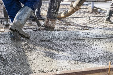 İnşaat alanına beton döken işçiler. Güçlendirilmiş zemin betonarme