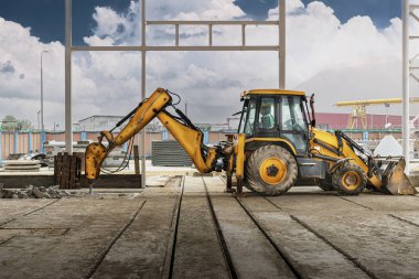 Endüstriyel hidrolik çekiçle ve kazıcıyla güçlendirilmiş beton yapıların profesyonel yıkımı. Üretim alanındaki beton zeminin sökülmesi. Enkaz ve beton kırıntıları.