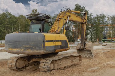 Büyük kovalı ağır bir sürüngen kazıcısı işe hazırlanıyor. Toprak işçiliği için ağır inşaat malzemeleri. Taş ocağı kazıcısı. Bölgenin gelişimi