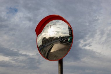 Otoparktan güvenli çıkış için açık hava panoramik aynası. İnşaat halindeki tek katlı binanın yansıması.
