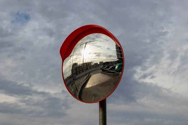 Otoparktan güvenli çıkış için açık hava panoramik aynası. İnşaat halindeki tek katlı binanın yansıması.