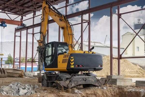 Endüstriyel hidrolik çekiç ve kazıcı kullanılarak güçlendirilmiş beton yapıların profesyonel yıkımı. Metal alaşımlı çubuklar. Beton enkazı ve kırıntıları