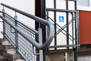 Bir apartmanın girişinde asansörlü tekerlekli sandalye rampası.