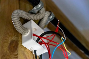 Duvardaki kutuya elektrik kabloları yerleştirilmiş. Evin etrafına elektrik kabloları dağıtılıyor.