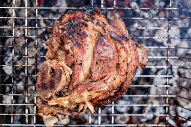 Izgara sulu domuz budu. İştah açıcı eklem ya da yaban domuzu toynağı. Kömürde domuz budu pişirmek. Yakın plan.