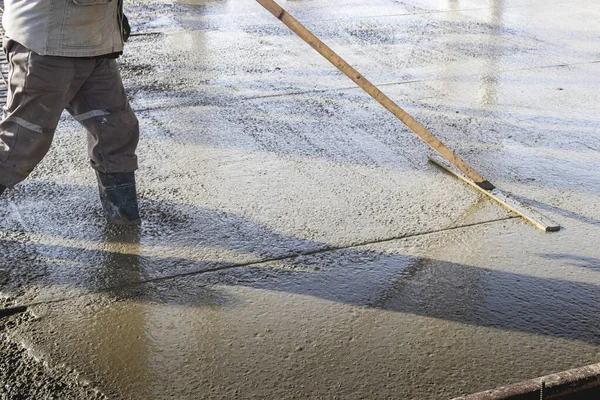 Construction Worker Leveling Poured Concrete Floor Industrial Workshop Legs Boots — Stock Photo, Image