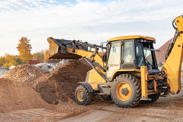 挖掘机装载机用一个桶在建筑工地运送沙子 土方工程专业建筑设备 — 图库照片