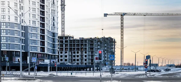 Bir konut binasının monolitik çerçevesi. Şehirde modern bir konut inşaatı. Yol altyapısı. İnşaat halindeki bir yerleşim alanının panoraması
