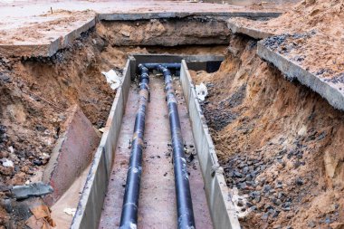Yeraltı iletişimi. Beton tepsilerde ısıtma boruları. İletişim kurmak için güçlendirilmiş beton tepsiler kazılmış sipere konur.