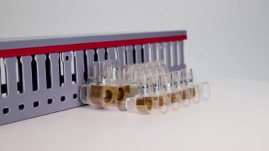 Beyaz arka planda elektrik terminali blokları ve dağıtım blokları. Farklı voltajların elektrik kablolarını bağlıyorum. Elektrik kablolarını döşemek için kanal. Elektrikçi. Yakın plan..