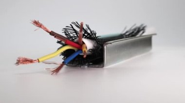 İzolasyonda elektrikli bakır kablo ve beyaz zemin üzerinde özel bir metal kanal. Elektrik kablosu kurulumu. Zor koşullarda kablo yalıtımı. Yakın plan..