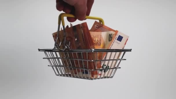 白い背景に男の手にショッピングカートでユーロ紙幣 接近中だ ビジネスと金融 現金の概念と金融資産の蓄積 — ストック動画