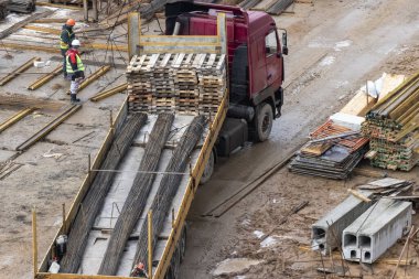 Büyük bir kamyon şantiyeye malzeme getiriyor. Monolitik güçlendirilmiş beton ev inşaatı için metal teçhizatı. Yapı malzemelerinin kabulü