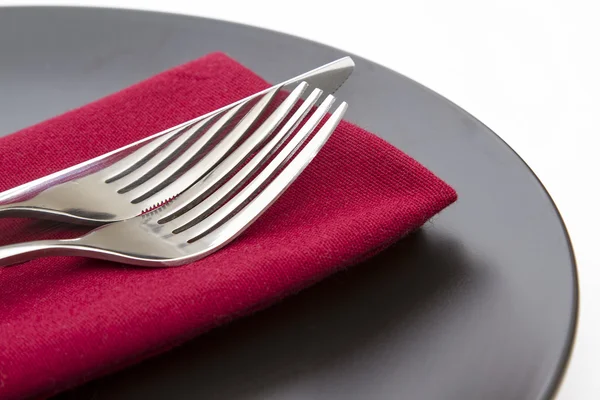 Cutlery on red napkin with plate — Stock Photo, Image