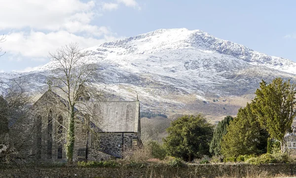 Besneeuwde berg met st marys kerk in beddgelert, Noord-wales — Stockfoto