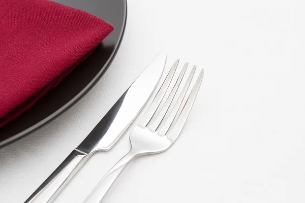Placa preta com faca e garfo com guardanapo vermelho — Fotografia de Stock