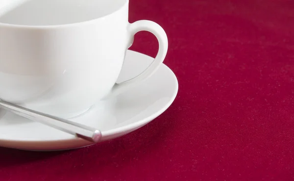 Taza blanca y platillo en mantel rojo — Foto de Stock