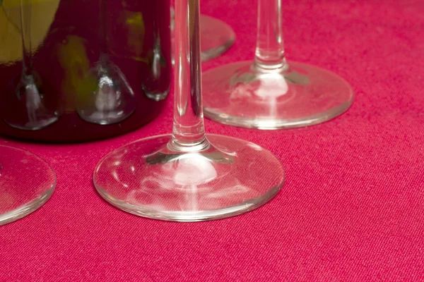 Wine glasses and wine bottle on red tablecloth — Stock Photo, Image