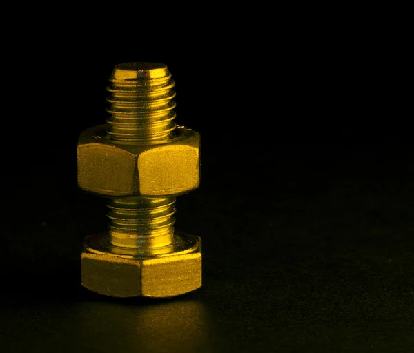 Siyah altın aydınlatma ile cıvata ve somun — Stok fotoğraf