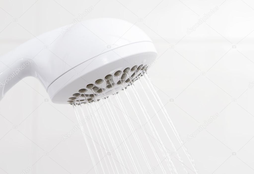 Water flowing from bathroom plastic white shower head