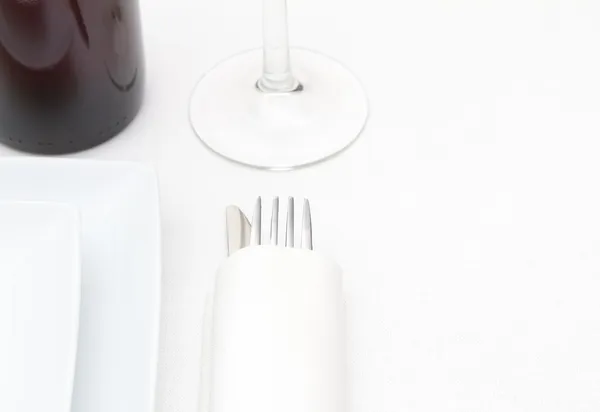 Coloque a configuração com pratos brancos, talheres e vinho tinto em pano branco — Fotografia de Stock