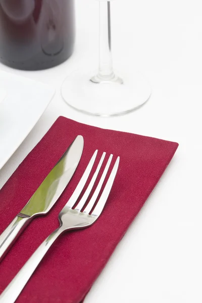 Place setting with white plates and red wine with red napkin — Stock Photo, Image