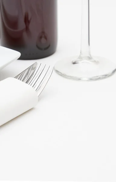 Place setting with plates and red wine on white cloth — Stock Photo, Image