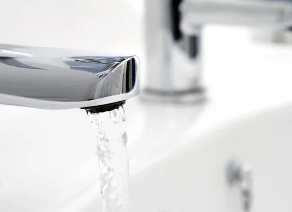Water flowing from tap into basin — Stock Photo, Image