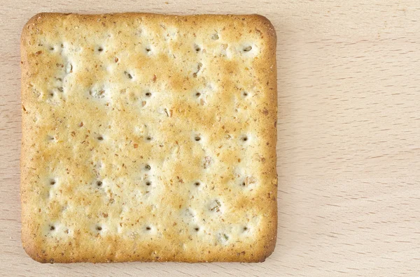 Ein Vollkorncracker auf Holzbrett — Stockfoto