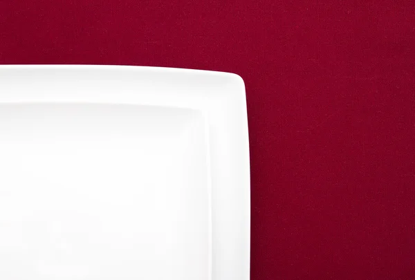 Twee witte platen op rode doek — Stockfoto