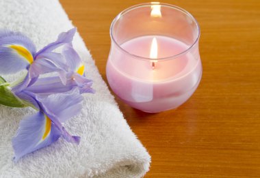 Mor iris ve mum spa konsepti ile beyaz havlu