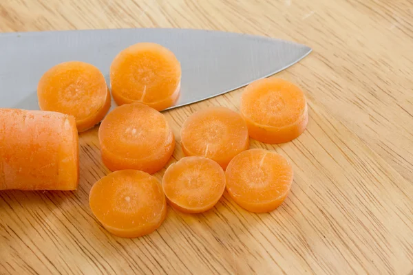 Sliced carrot on wooden chopping board — Stock Photo, Image