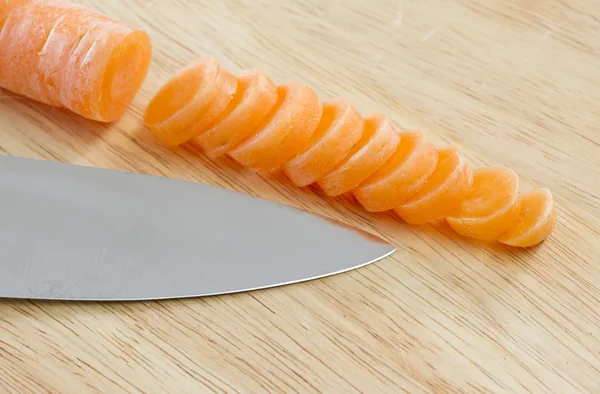 Carrot sliced on wooden chopping board
