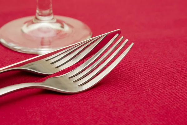 Garfo de faca e vidro na toalha de mesa vermelha — Fotografia de Stock