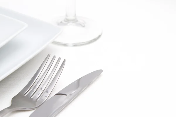 Middag plats inställningen. vit kvadrat Kina plattor med silver bestick och glas — Stockfoto