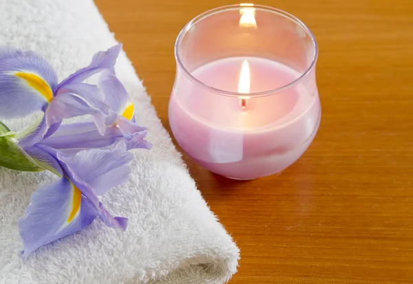 White towel with purple iris and candle spa concept — Stock Photo, Image