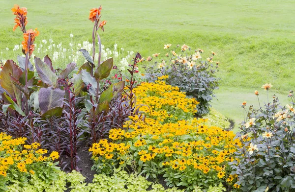 Kleurrijke bloemenperken en gras in een formele tuin — Stockfoto