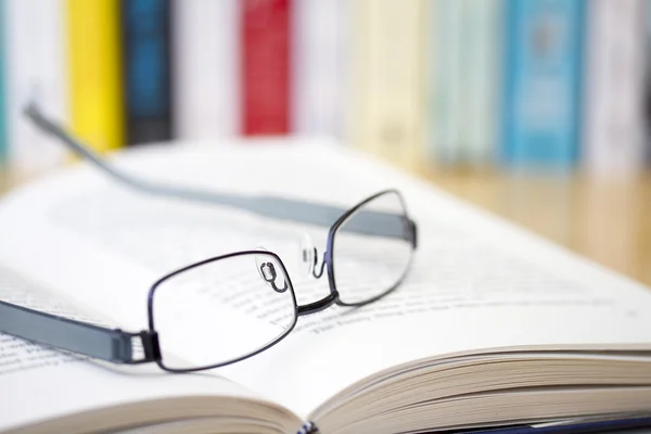 Book with glasses on desk — Stock Photo, Image