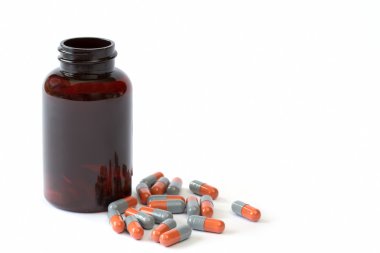 kahverengi şişe üzerinde beyaz ile gri ve turuncu kapsül