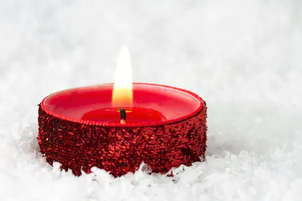 Czerwony świecący tealight na śniegu — Zdjęcie stockowe