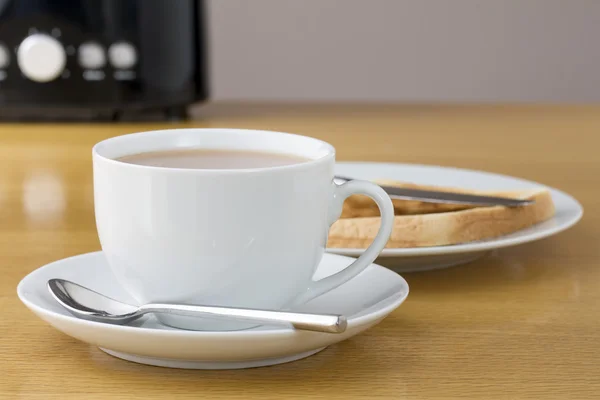 Xícara de chá com fatia de torrada e uma torradeira — Fotografia de Stock